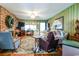 Spacious living room with brick fireplace, vintage decor, and a ceiling fan for added comfort at 404 13Th Ave. S, Myrtle Beach, SC 29577