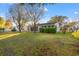 Well-maintained backyard with manicured lawn, trees, and a building with sliding glass doors at 404 Snowy Egret Dr., Murrells Inlet, SC 29576