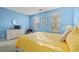 Cozy bedroom showcasing a TV, a wicker dresser and chair, and a queen bed with yellow comforter at 404 Snowy Egret Dr., Murrells Inlet, SC 29576