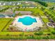 Aerial view of a community pool with ample seating and a playground set surrounded by lush landscaping at 4053 Taranto Loop # C, Myrtle Beach, SC 29579