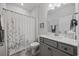 Cozy bathroom featuring a shower with a patterned curtain and a gray vanity at 4449 Honir Dr., Myrtle Beach, SC 29579