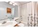 Bright bathroom featuring a vanity, toilet, and shower-tub combination with a neutral-patterned curtain at 4486 Little River Inn Ln. # 2107, Little River, SC 29566