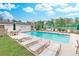 Community swimming pool surrounded by lounge chairs and lush landscaping under a sunny sky at 4486 Little River Inn Ln. # 2107, Little River, SC 29566
