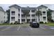 Attractive condo building featuring multi-story units and mature palm trees in a parking lot setting at 477 White River Dr. # 32-H, Myrtle Beach, SC 29579