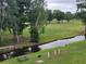 Scenic golf course view with a creek, mature trees, and lush green grass at 477 White River Dr. # 32-H, Myrtle Beach, SC 29579