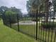 View of the community pool from behind a black iron fence with lush green landscaping at 477 White River Dr. # 32-H, Myrtle Beach, SC 29579