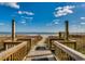 Scenic beach access path with wooden walkway leading to the sandy shore and ocean at 4800 S Ocean Blvd. # 504, North Myrtle Beach, SC 29582