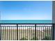 Relax with ocean views from the condo, featuring a black metal railing and beach in the distance at 4800 S Ocean Blvd. # 504, North Myrtle Beach, SC 29582
