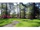 Lush front yard with a sidewalk winding through vibrant green grass and blooming trees at 5001 Little River Rd. # W-211, Myrtle Beach, SC 29577