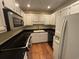 Galley kitchen with white cabinets, stainless steel appliances, and black countertops at 5001 Little River Rd. # W-211, Myrtle Beach, SC 29577