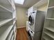 Laundry room with stacked white washer and dryer and custom shelving at 5001 Little River Rd. # W-211, Myrtle Beach, SC 29577
