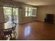 Living room with hardwood floors, large window with shutter, sliding glass door to a balcony, and a wooden dining table at 5001 Little River Rd. # W-211, Myrtle Beach, SC 29577