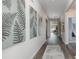 Inviting home hallway with stylish fern artwork, wood-look flooring and a view to the naturally lit living area at 5141 Yellowstone Dr., Conway, SC 29526