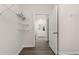 Spacious walk-in closet with open shelves and a view of a bathroom with white cabinets at 5141 Yellowstone Dr., Conway, SC 29526