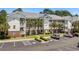 Spacious condo featuring covered balconies, palm trees, brick accents, and ample parking in a convenient location at 6015 Catalina Dr. # 534, North Myrtle Beach, SC 29582