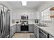 Modern kitchen with stainless steel appliances, gray lower cabinets, white upper cabinets and tiled floor at 6015 Catalina Dr. # 534, North Myrtle Beach, SC 29582