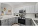Updated kitchen features gray lower cabinets, white upper cabinets and stainless steel appliances at 6015 Catalina Dr. # 534, North Myrtle Beach, SC 29582