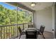 Overhead view of a porch table and chairs, neutral flooring, white railing and view of surrounding trees at 6015 Catalina Dr. # 534, North Myrtle Beach, SC 29582