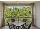 Screened porch with outdoor table and chairs offers a relaxing outdoor space surrounded by trees at 6015 Catalina Dr. # 534, North Myrtle Beach, SC 29582