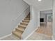 Carpeted stairway leads to the upper level with neutral walls and a combination of tile and wood flooring at the base at 6703 Jefferson Pl. # B7, Myrtle Beach, SC 29572