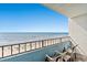 Balcony view overlooking the beach with chairs for relaxing by the ocean at 7100 N Ocean Blvd. N # 601, Myrtle Beach, SC 29572