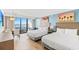 Bright bedroom featuring two beds, a dining table, a balcony with ocean view, and colorful tropical art at 7100 N Ocean Blvd. N # 601, Myrtle Beach, SC 29572