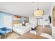 Bright bedroom with two beds, an accent chair, dining table, and mounted TV, giving a relaxing ambiance at 7100 N Ocean Blvd. N # 601, Myrtle Beach, SC 29572