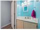 Bright powder room features blue walls, white cabinets, and wood-look floors at 775 Plantation Dr. # 28, Little River, SC 29566