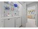 Bright laundry room with shelving over white, front-loading washer and dryer units at 775 Plantation Dr. # 28, Little River, SC 29566