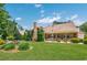 Expansive backyard featuring a stone chimney, well-manicured lawn, lovely landscaping, and inviting covered patio area at 784 Caines Landing Rd., Conway, SC 29526