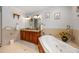 This bathroom features a large soaking tub with wood paneling, a double vanity, and neutral tiling at 784 Caines Landing Rd., Conway, SC 29526
