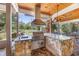 Fully equipped outdoor kitchen with granite countertops, stainless steel grill, and a stone surround, perfect for entertaining at 784 Caines Landing Rd., Conway, SC 29526