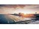Picturesque beach scene with a long wooden pier and high-rise buildings in the distance at sunset at 814 Night Heron Ln., Myrtle Beach, SC 29572