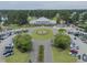 Aerial view showcasing a clubhouse with well-maintained grounds, circular driveway, and ample parking at 8855 Radcliff Dr. Nw # 53C, Calabash, NC 28467