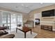 Comfortable living room with wood floors, ceiling fan, and slider doors leading to an outdoor screened patio at 8855 Radcliff Dr. Nw # 53C, Calabash, NC 28467