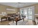 Living room with vaulted ceiling, wood floors, comfortable seating, and slider door to the screened patio overlooking the water at 8855 Radcliff Dr. Nw # 53C, Calabash, NC 28467
