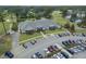 Aerial view of the clubhouse, parking lot, and golf course with mature trees at 8855 Radcliff Dr. Nw # 53D, Calabash, NC 28467