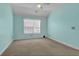 Bright bedroom with soft aqua walls, carpeting, and a window with natural light at 8855 Radcliff Dr. Nw # 53D, Calabash, NC 28467
