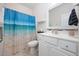 Cozy bathroom with a single sink vanity, a shower with a blue beach-themed curtain, and tiled floors at 924 Sorano St., Myrtle Beach, SC 29579