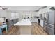 Open-concept kitchen with large island, stainless steel appliances, and adjacent living area at 924 Sorano St., Myrtle Beach, SC 29579