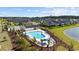 Aerial view of community pool with lounge chairs and clear blue water, surrounded by houses and a pond at 924 Sorano St., Myrtle Beach, SC 29579