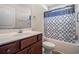 Bathroom features a tub with a dark blue decorative shower curtain, and matching cabinetry at 95 Timber Run Dr., Georgetown, SC 29440