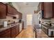 Well-lit kitchen featuring dark wood cabinets, stainless steel appliances, and luxury vinyl plank flooring at 95 Timber Run Dr., Georgetown, SC 29440