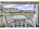 Relaxing balcony view with white table set, overlooks ocean and neighboring building at 9660 Shore Dr. # 208, Myrtle Beach, SC 29572