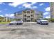Seagull condominium featuring multiple stories with blue roof accents and ample parking at 9660 Shore Dr. # 208, Myrtle Beach, SC 29572