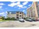 View of the Seagull condominium complex next to a high rise, with ample parking at 9660 Shore Dr. # 208, Myrtle Beach, SC 29572