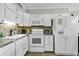 Bright kitchen featuring white appliances, tile backsplash, and ample cabinet space at 9660 Shore Dr. # 208, Myrtle Beach, SC 29572