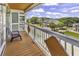 Balcony with a wooden deck and a blue Adirondack chair overlooking a neighborhood at 113-A Vista Dr., Garden City Beach, SC 29576