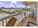 Balcony featuring a wooden deck with two blue Adirondack chairs, facing colorful beach houses at 113-A Vista Dr., Garden City Beach, SC 29576