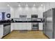 Modern kitchen with white cabinets, stainless steel appliances, and light wood floors at 113-A Vista Dr., Garden City Beach, SC 29576